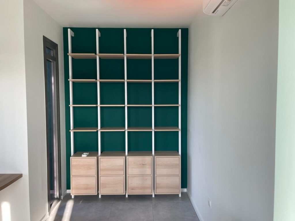 Custom office display and storage unit with wood shelving and cabinetry